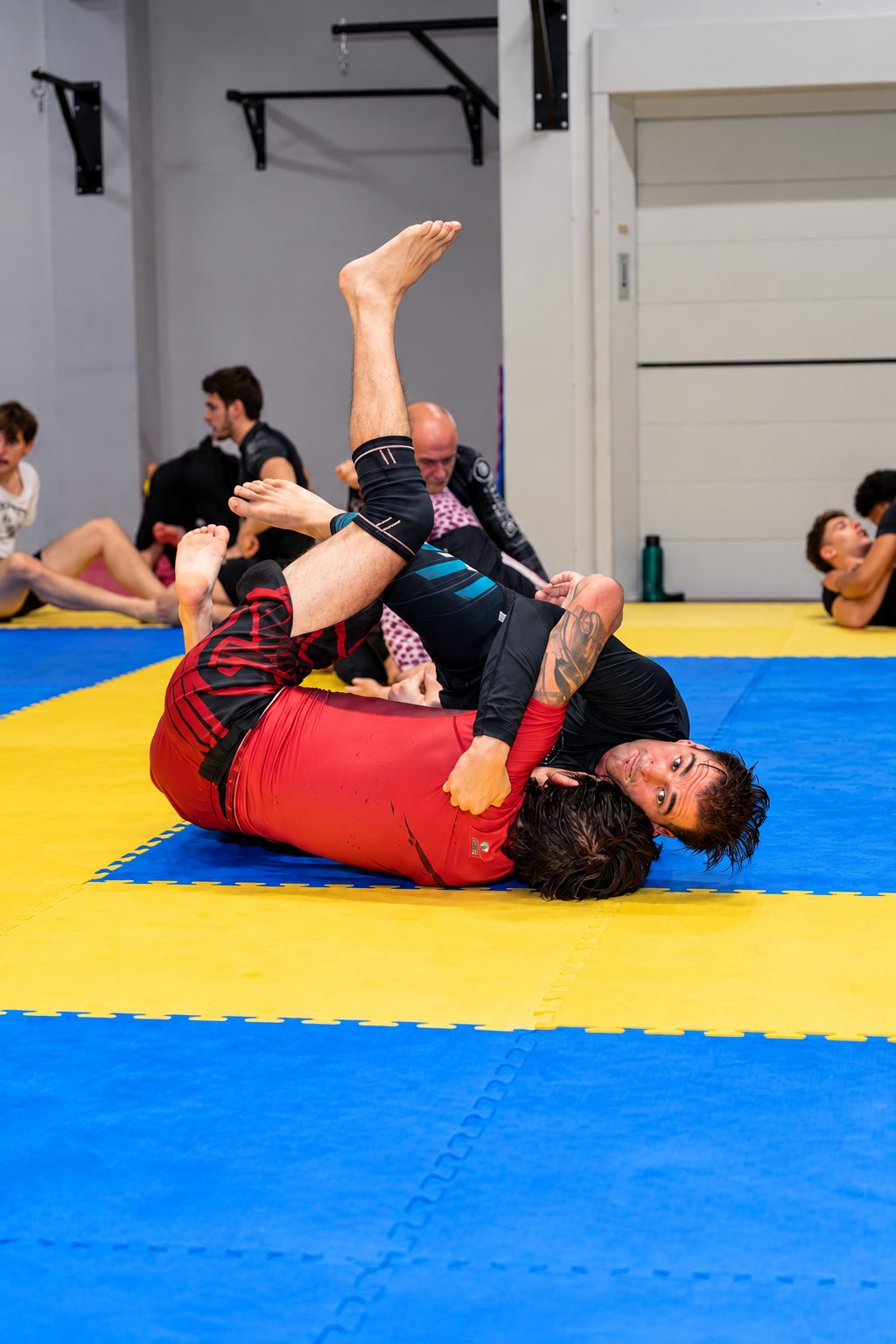Allenamento NoGi sul tatami giallo e blu, lavoro dalla guardia
